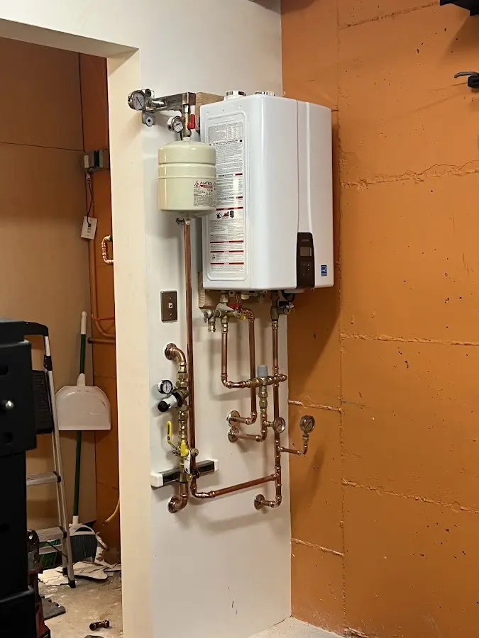 Plumbing technician inspecting water heater connections in Amwell